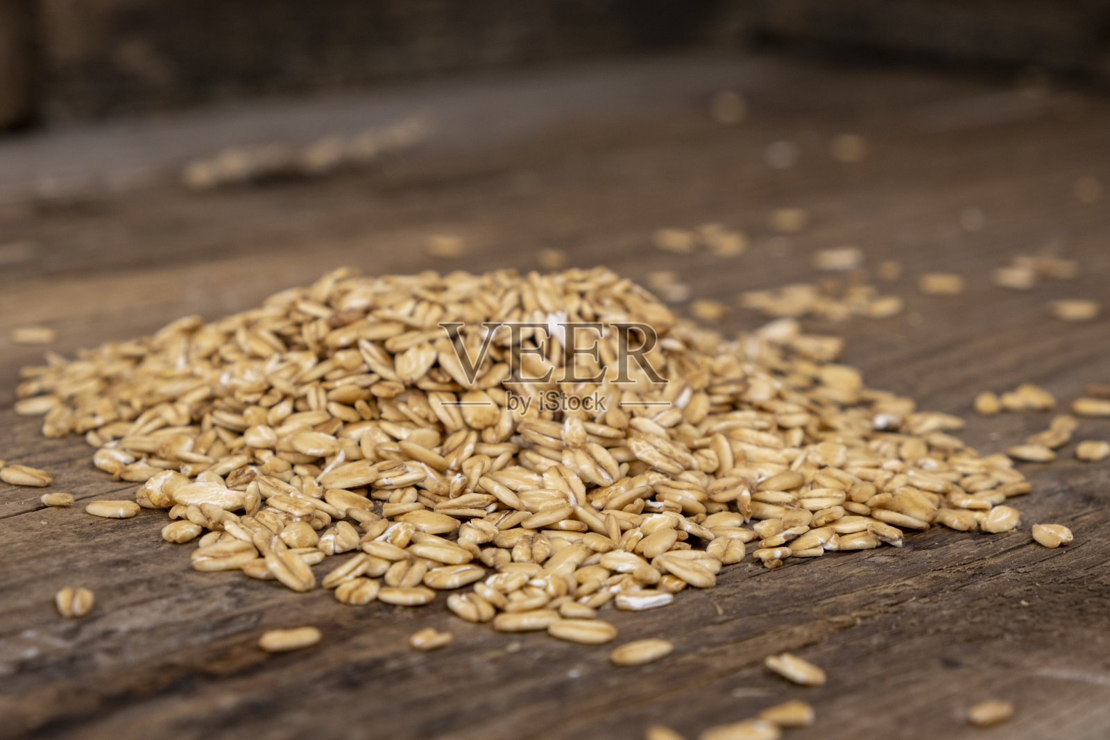 卷曲的全谷物燕麦堆在木制背景照片摄影图片