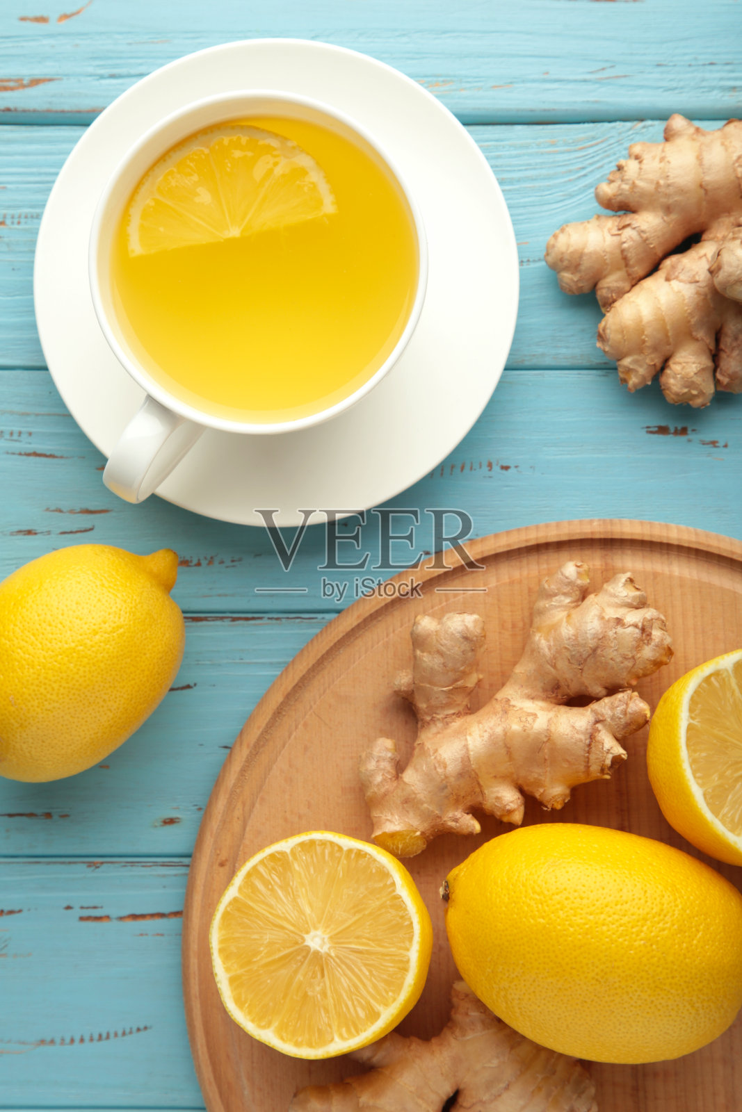 柠檬和蜂蜜的姜茶在蓝色木制背景上。前视图。照片摄影图片