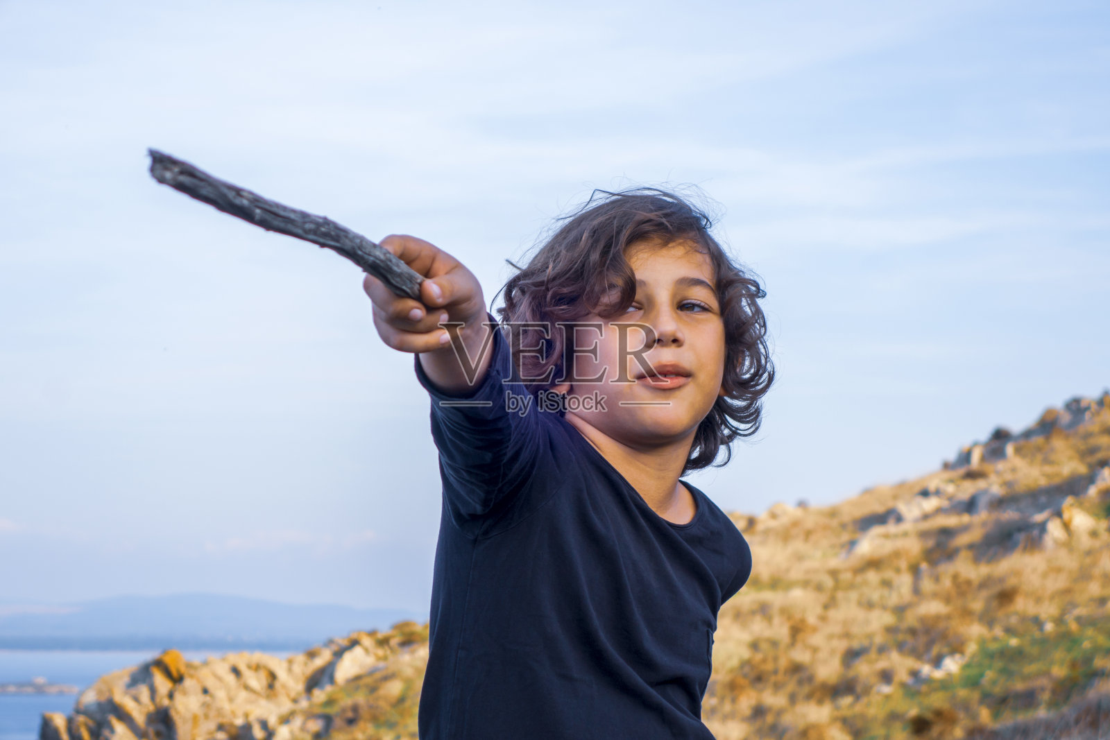 英俊的男孩在大自然中玩棍子照片摄影图片