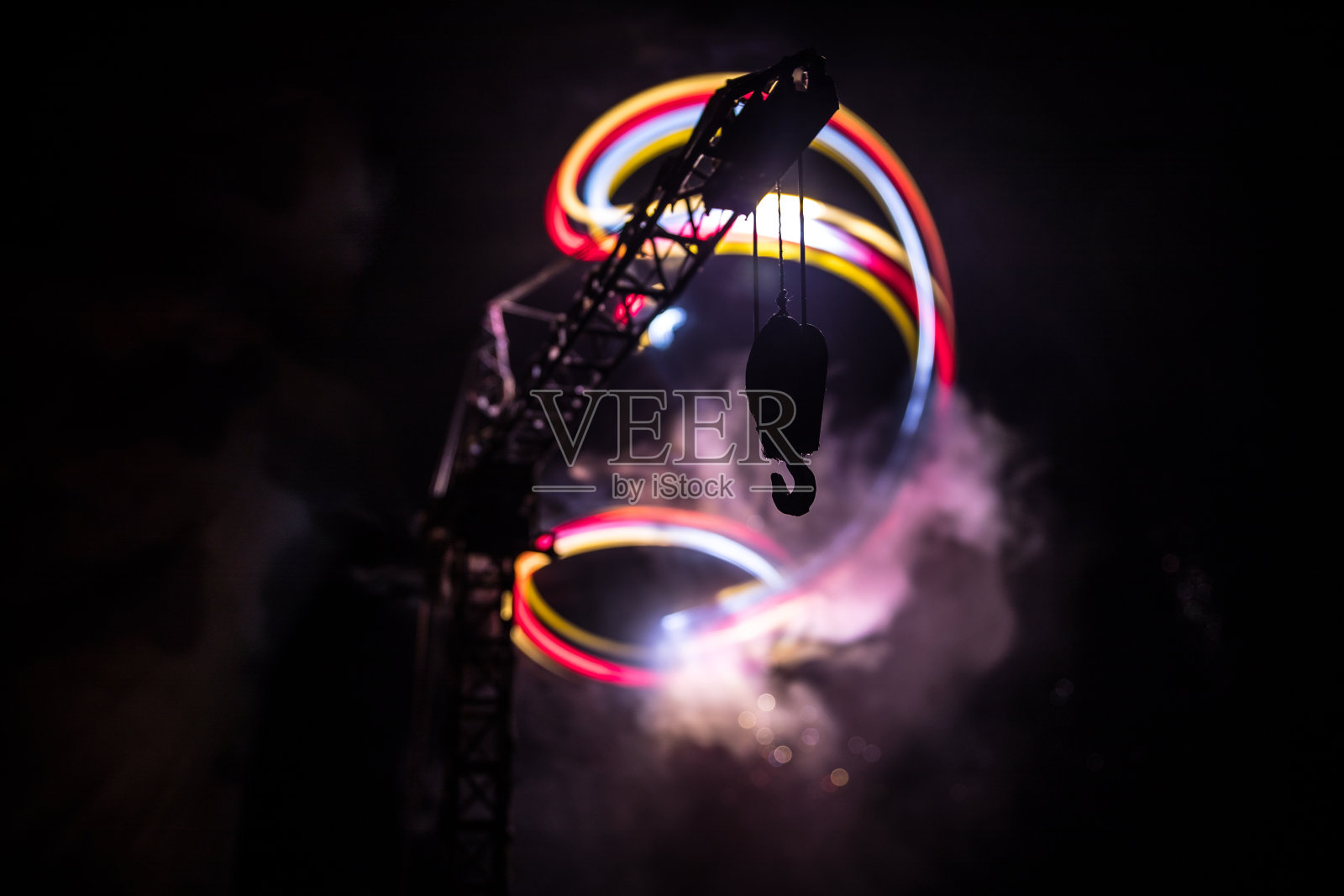 工业背景与建筑起重机剪影惊人的夜空与雾和背光。塔式起重机顶着雾蒙蒙的夜空。照片摄影图片