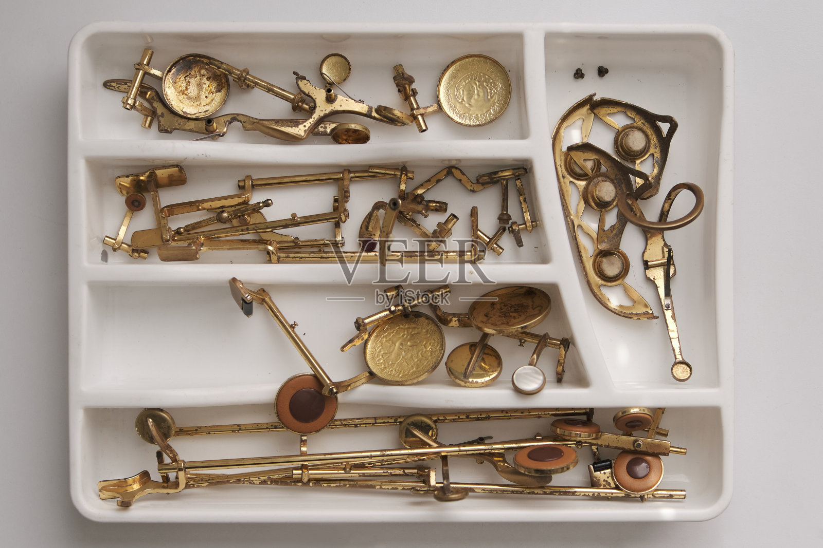 萨克斯管的部分琴键拆卸在一个白色的托盘上照片摄影图片