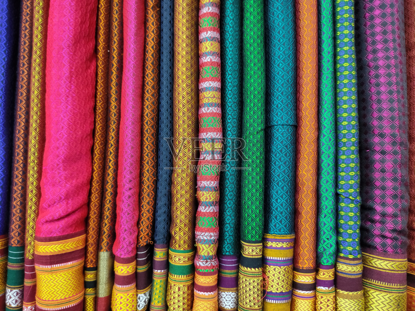 商店里有一卷卷的织物和纺织品。市场上有多种颜色的印度图案。印度马哈拉施特拉邦浦那的布店。照片摄影图片