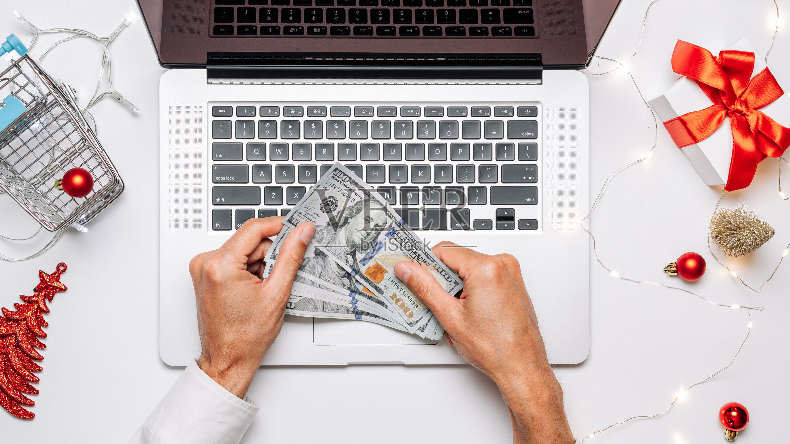 在线的礼物。圣诞礼盒红丝带,手推车和笔记本电脑在平铺互联网网上购物组成。圣诞促销和折扣促销。照片摄影图片