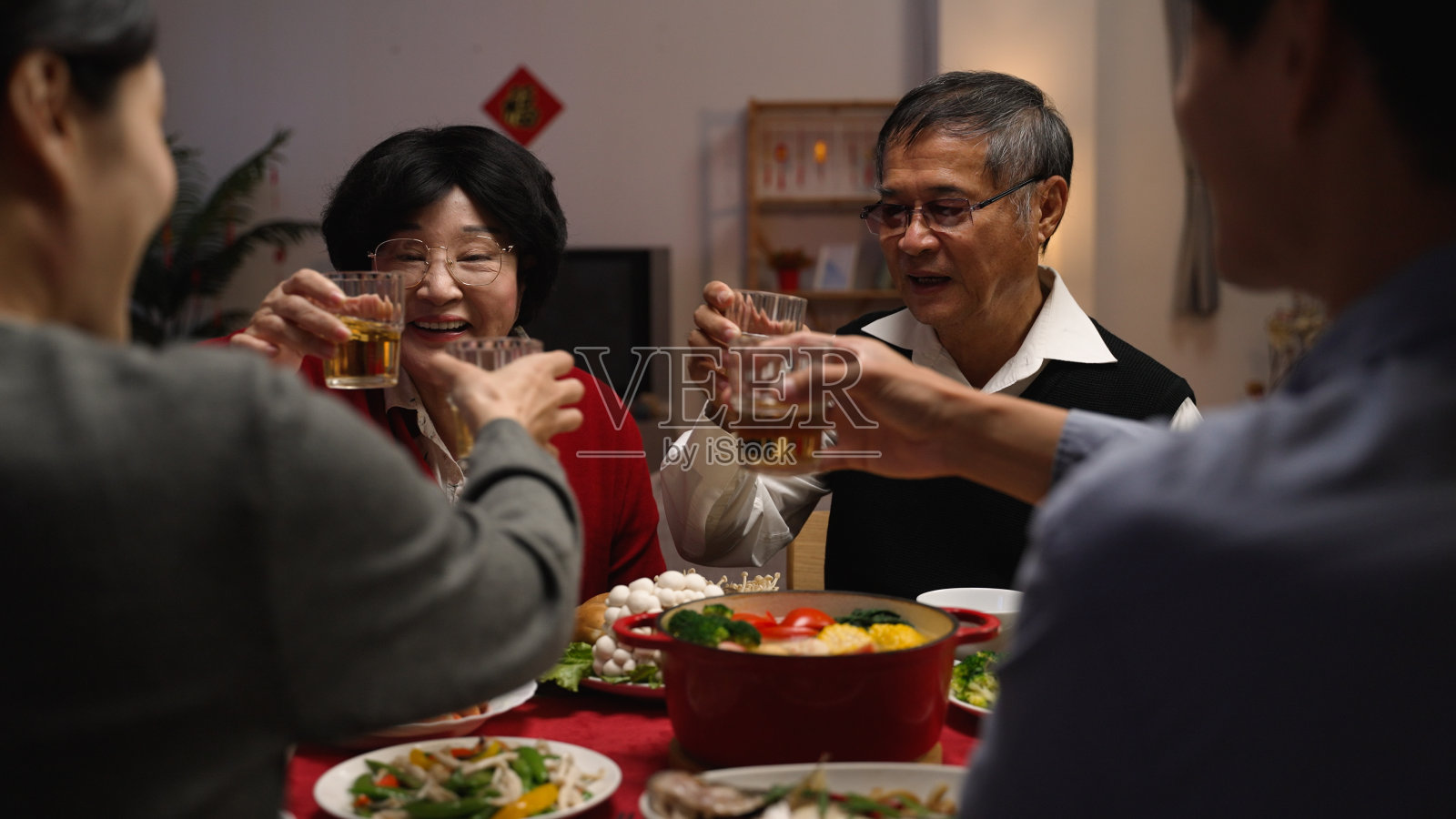 春节年夜饭:祖父母向家人祝酒照片摄影图片