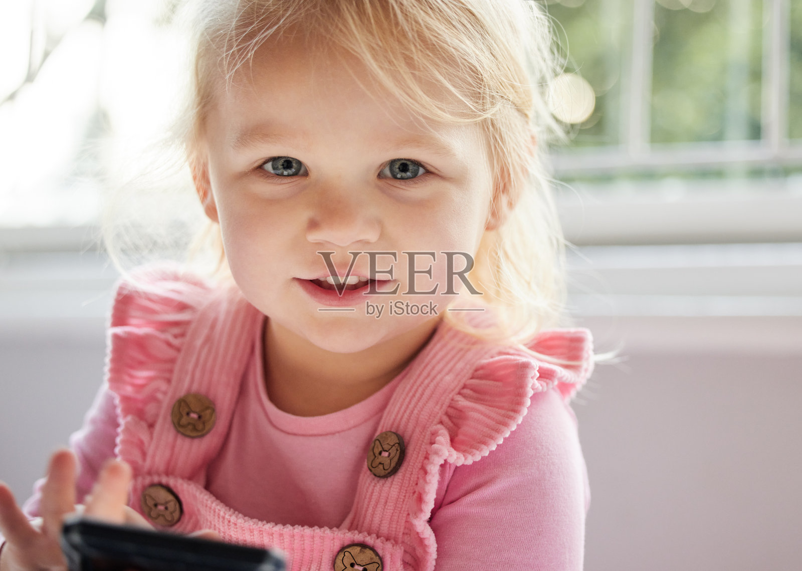 在家使用手机的小女孩照片摄影图片