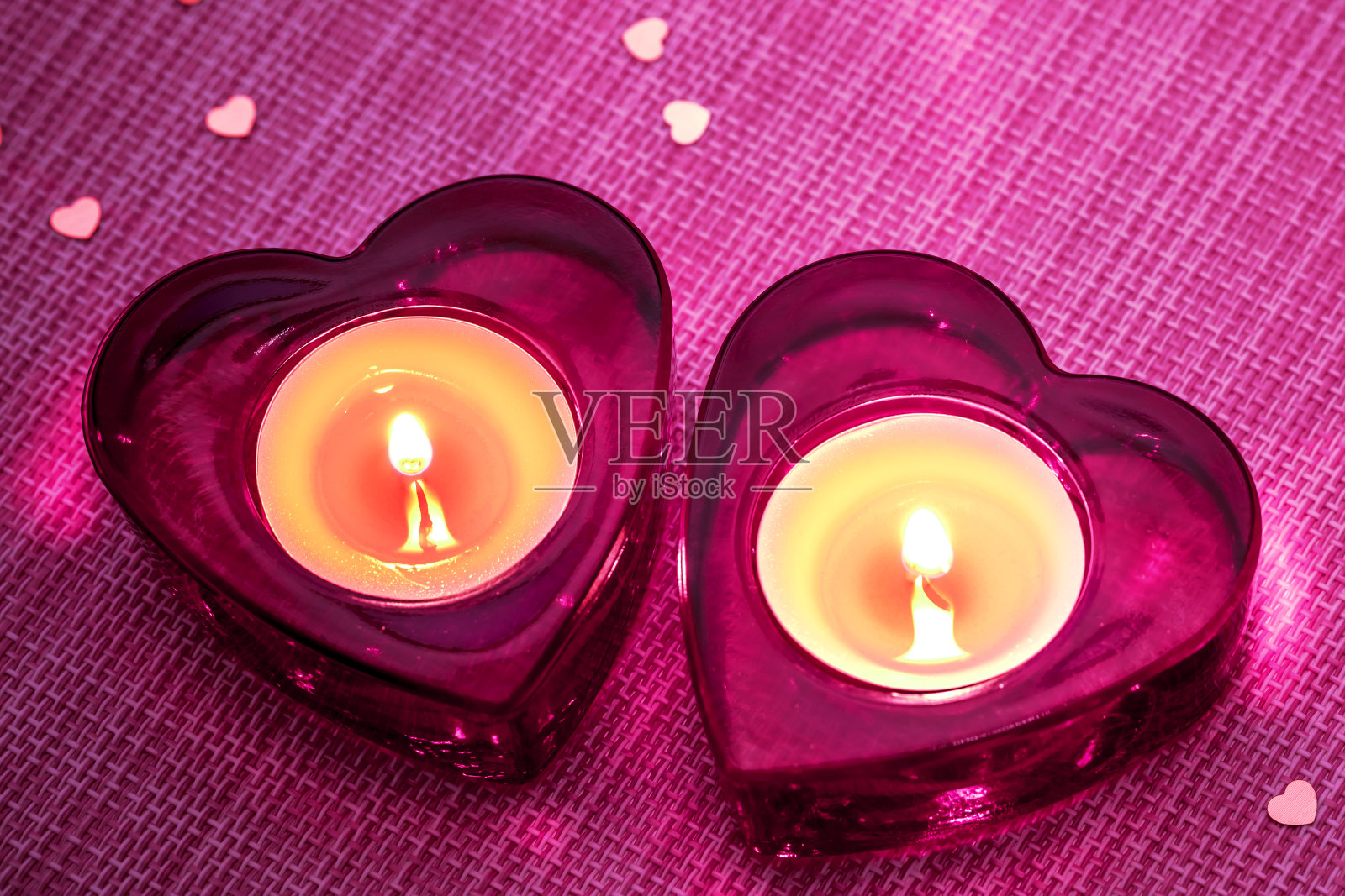 我们的心一起燃烧!!粉色背景上两根心型蜡烛照片摄影图片