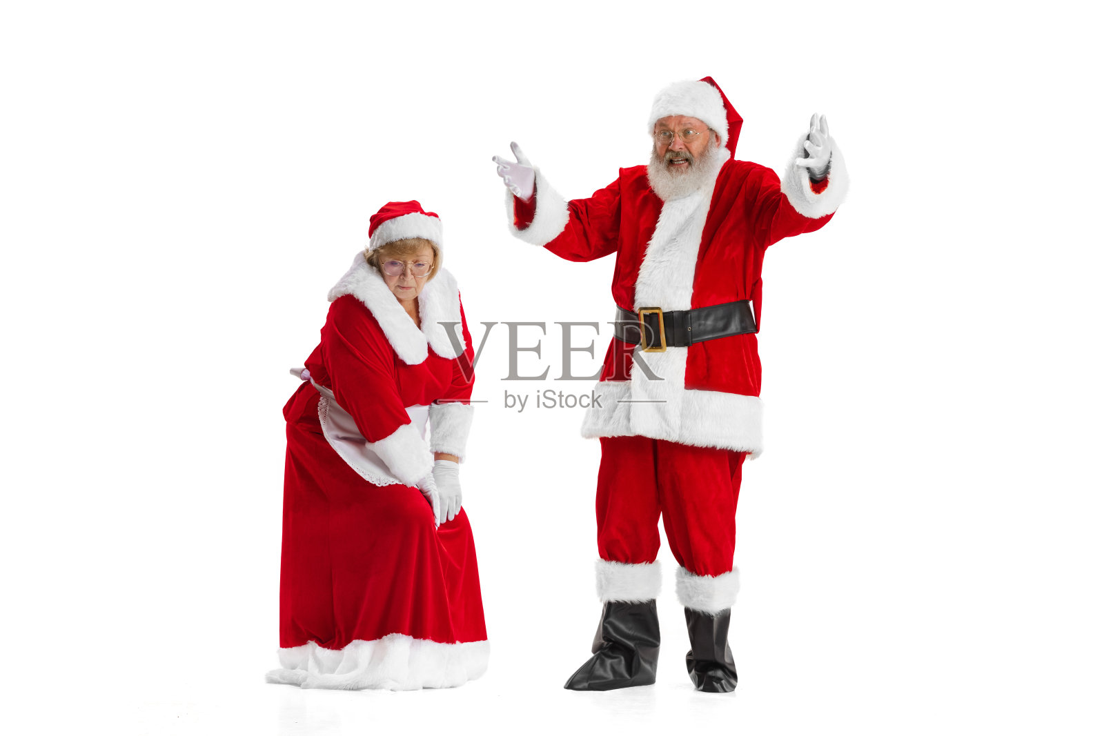 兴奋的老男人和漂亮的女人,圣诞老人和圣诞夫人在传统的新年服装孤立在白色的背景。照片摄影图片