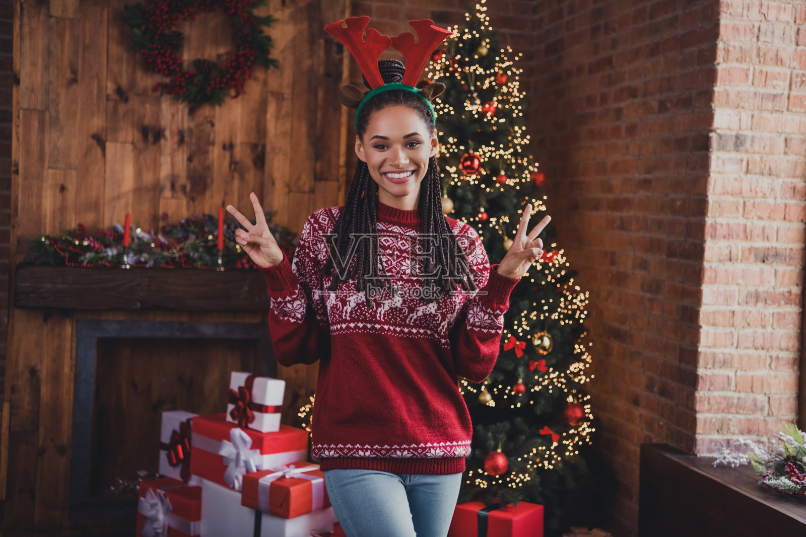友好的正面女士的照片有圣诞夜乐趣秀v标志穿角套头衫在室内装饰的家照片摄影图片