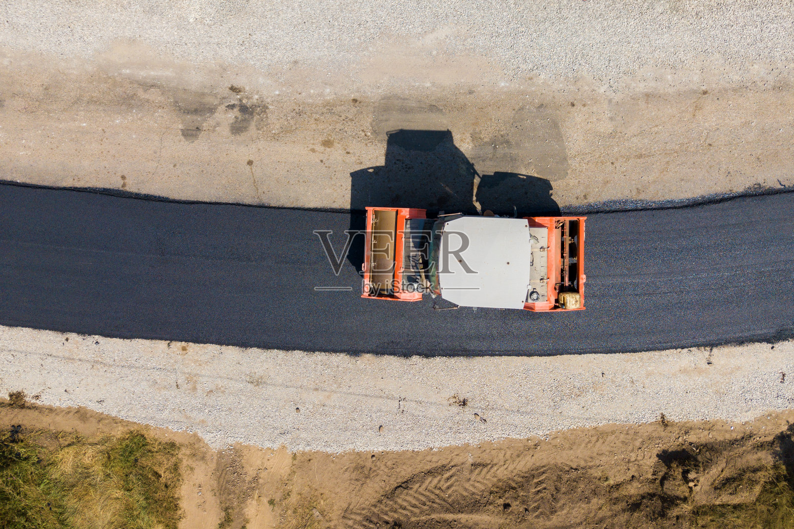 用蒸汽压路机施工的新道路鸟瞰图。照片摄影图片