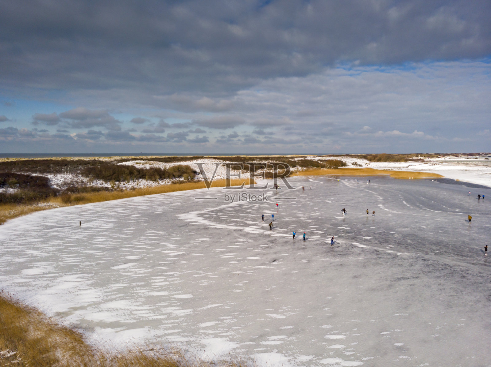 在荷兰,冬天在结冰的湖面上滑冰的人们照片摄影图片
