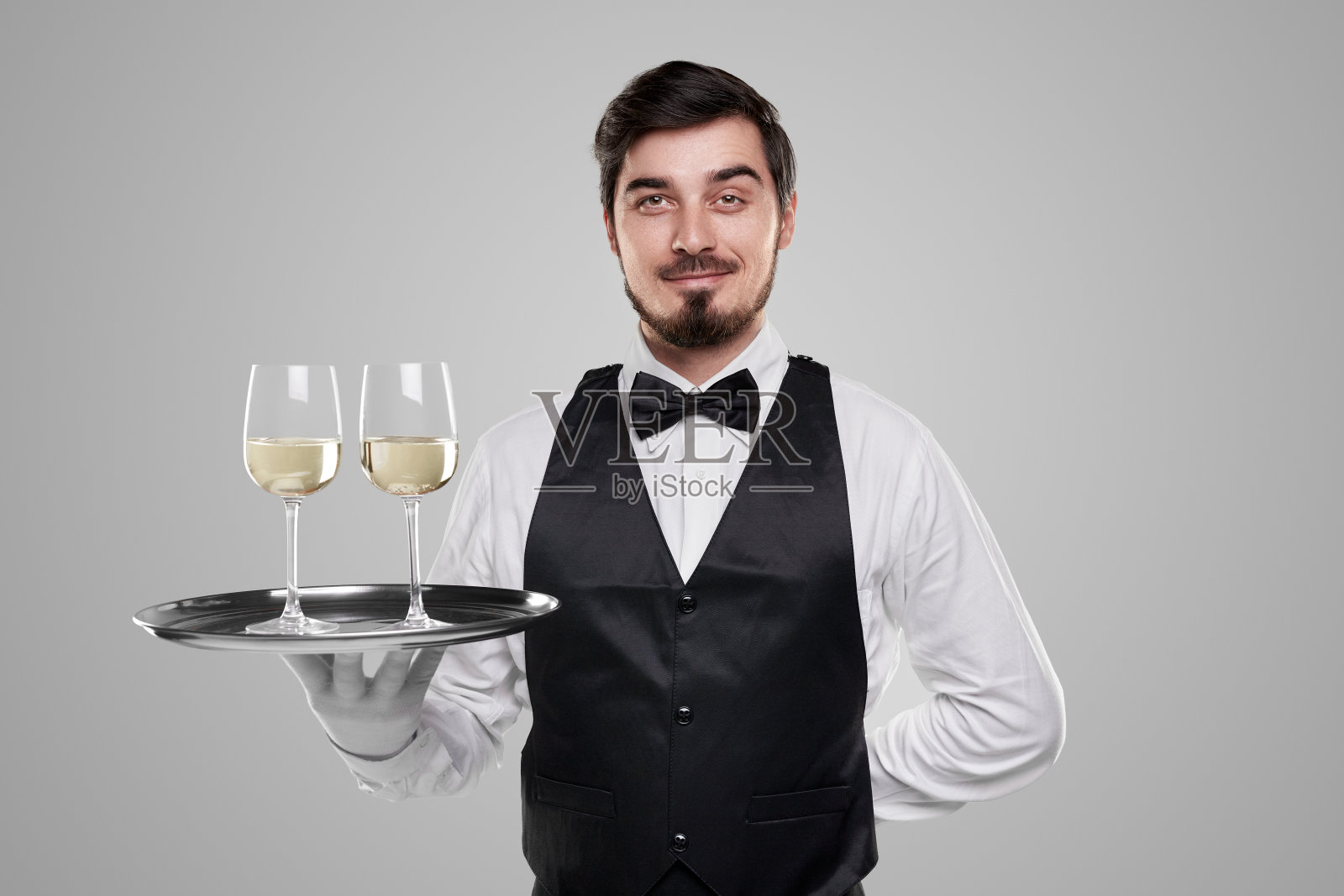 服务员在端酒时看着镜头照片摄影图片