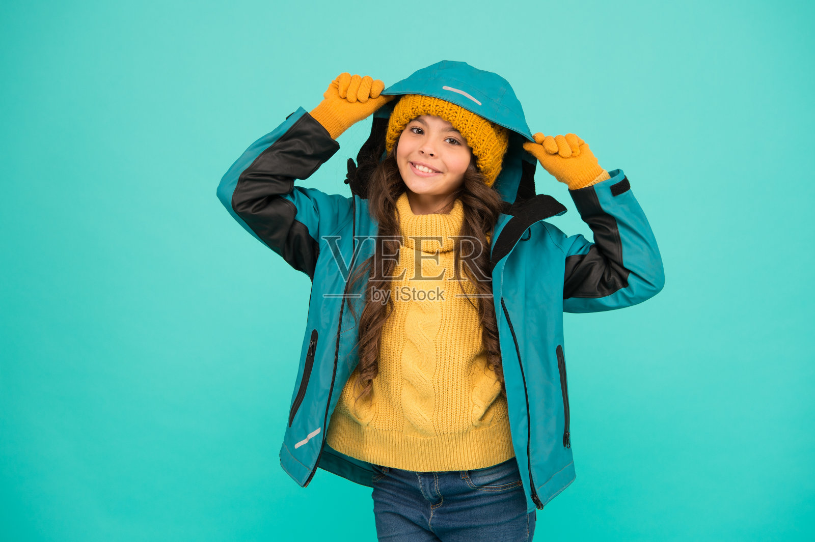 滑雪胜地的概念。冬天收集。孩子戴帽子,穿夹克。积极的休闲活动。运动风格。女孩喜欢冬天。寒假。防护服。快乐微笑的孩子。适当装备照片摄影图片