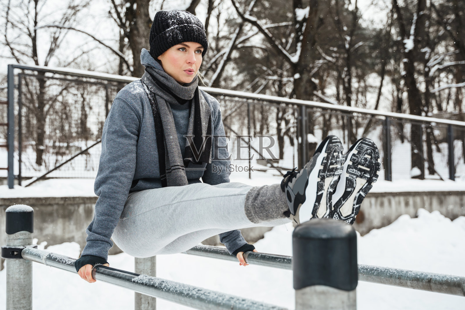 运动女子在她的冬季室外双杠锻炼照片摄影图片