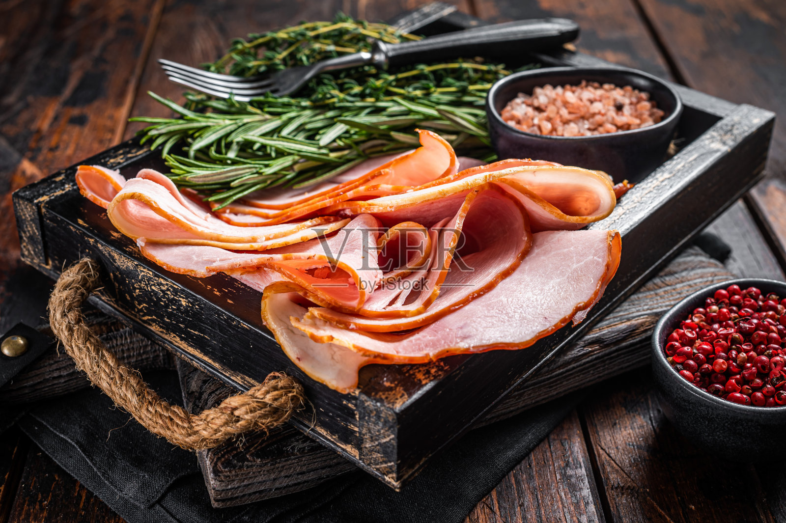 木盘意大利火腿片配百里香和迷迭香。木制背景。俯视图照片摄影图片
