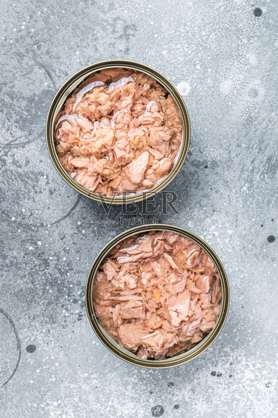 用金枪鱼罐头打开罐头。灰色的背景。俯视图照片摄影图片