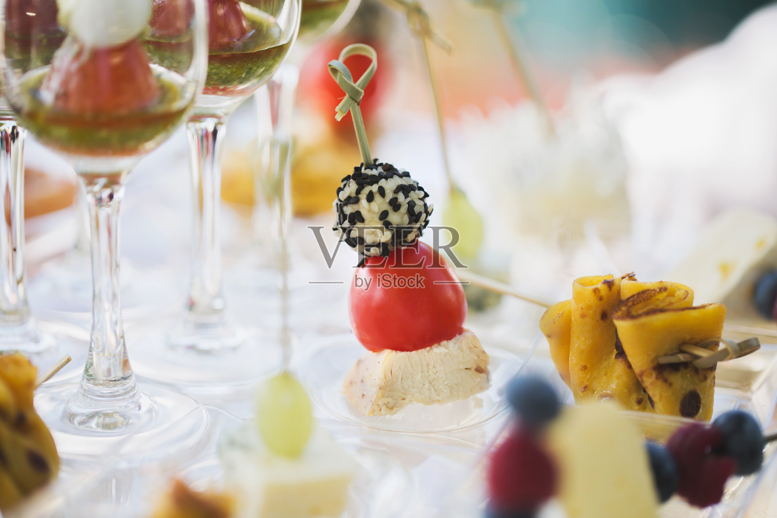 婚宴。小点心和酒杯放在玻璃桌上。照片摄影图片