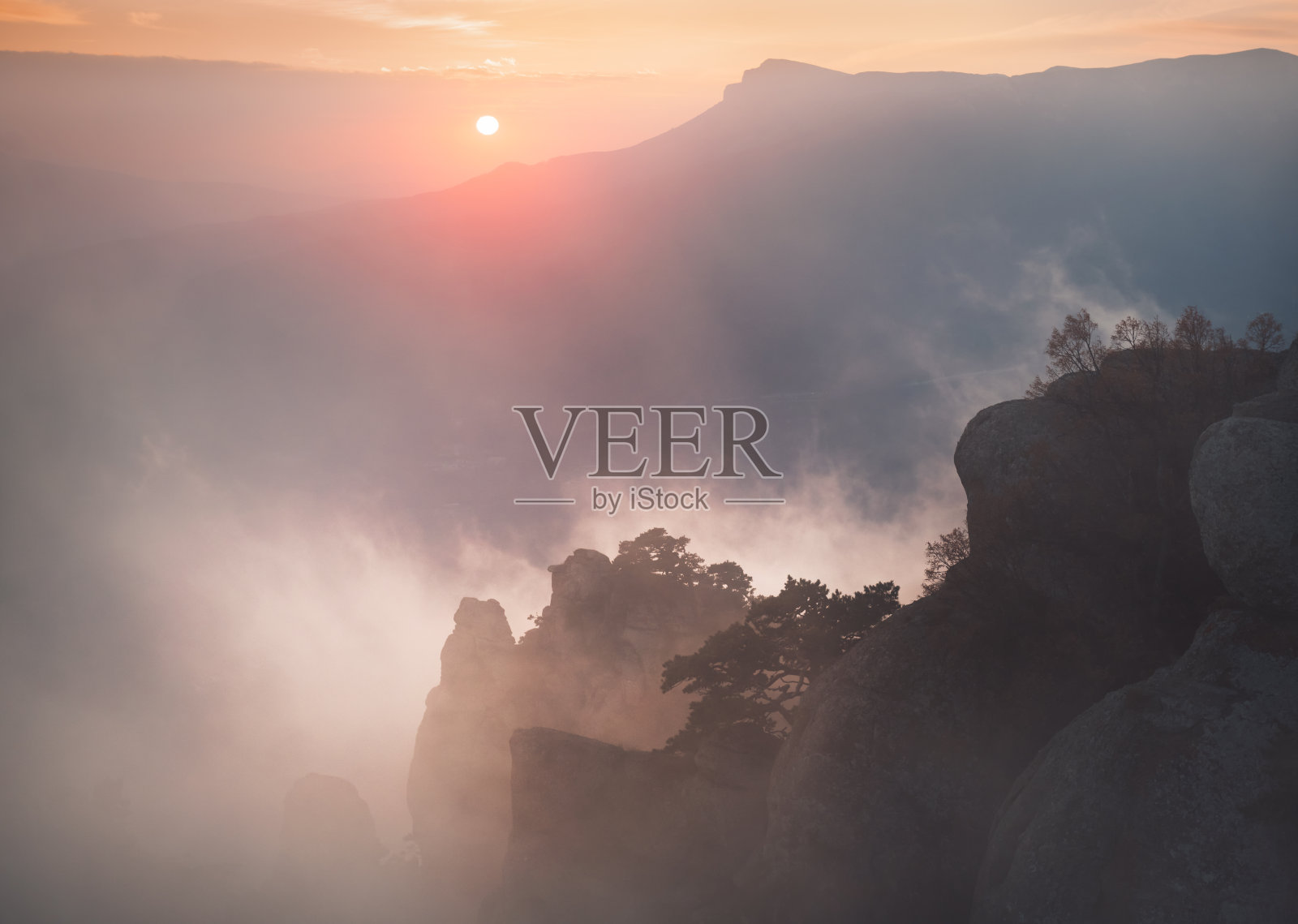 山上雾蒙蒙的日落。照片摄影图片