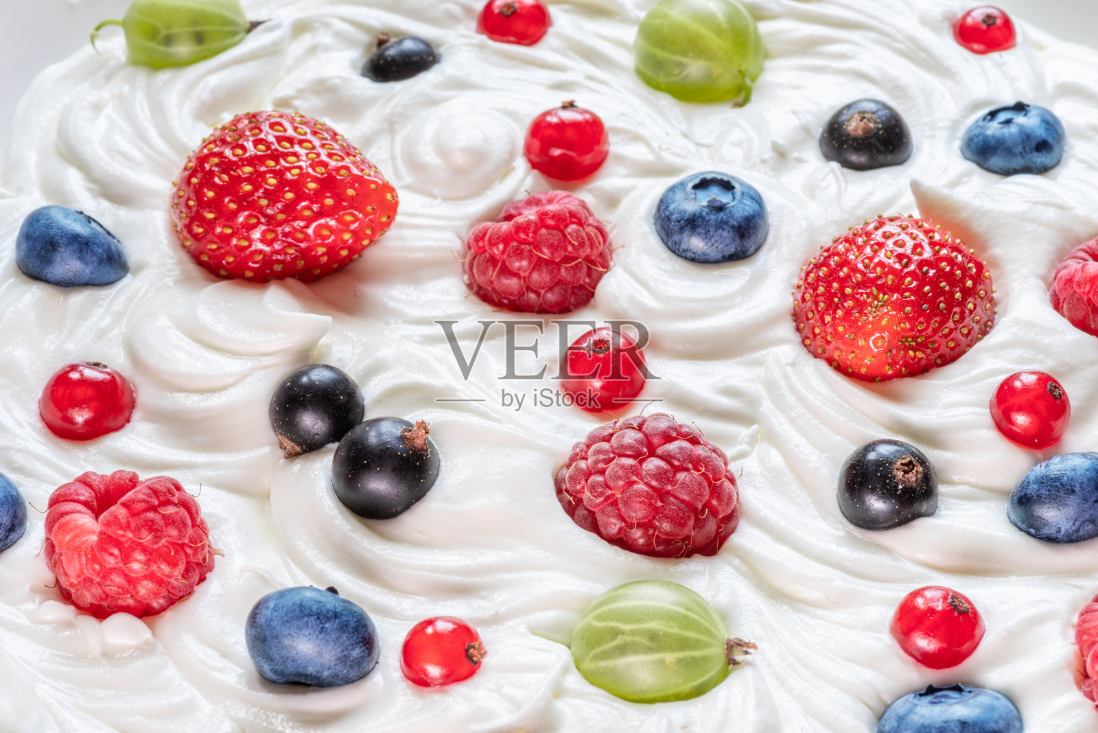 在酸奶或奶油中混合新鲜浆果。前视图。照片摄影图片