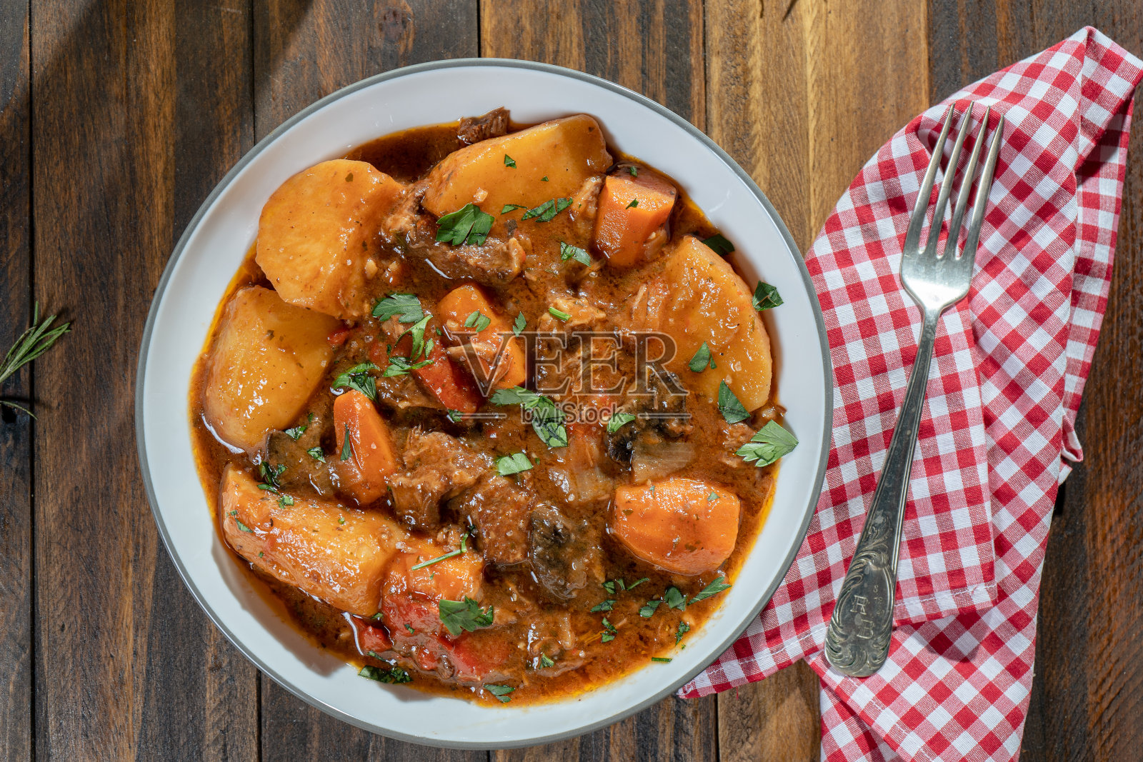 鸟瞰图:木桌上放着自制的肉、土豆和炖蔬菜照片摄影图片