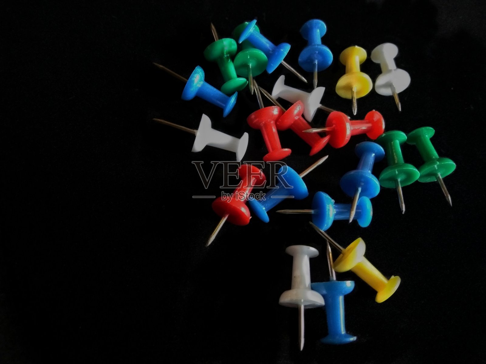多色推针拇指图钉孤立在黑暗的黑色背景照片摄影图片
