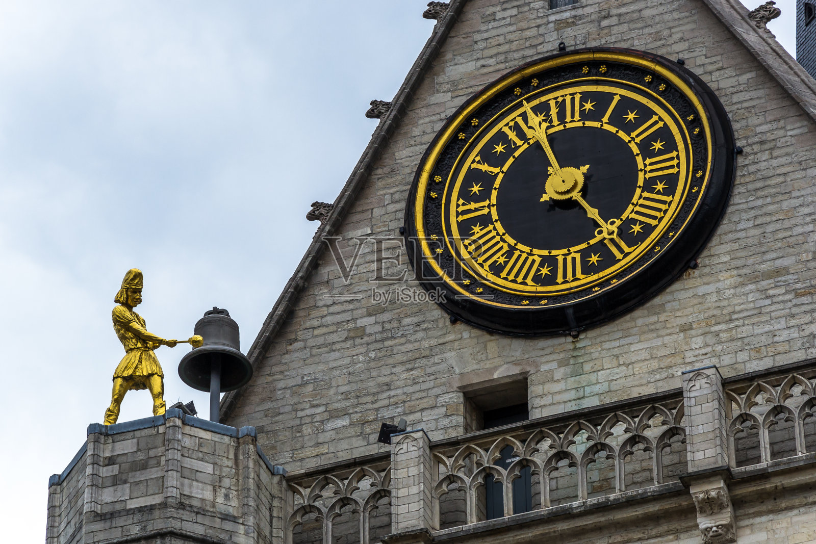 在比利时鲁汶的圣彼得教堂附近,一台金色的自动钟周期性地敲钟照片摄影图片