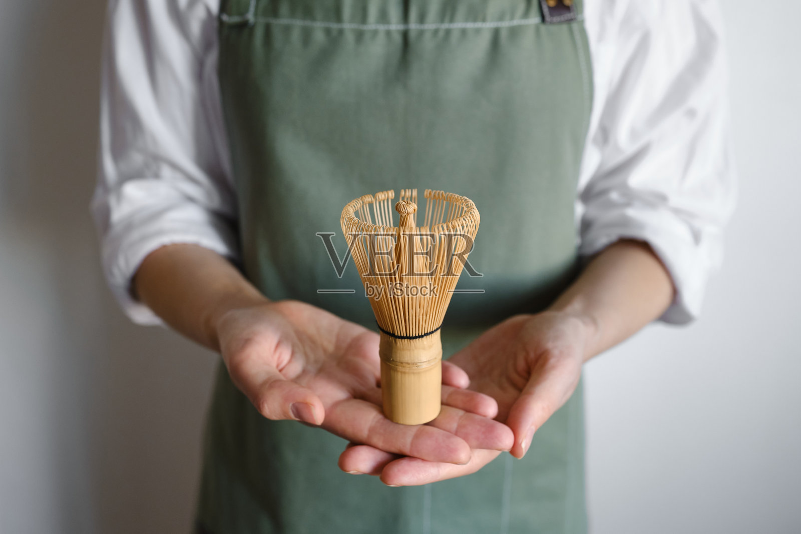竹抹茶在一个咖啡师女孩的手中搅拌。是时候喝传统抹茶了。特写抹茶搅拌照片摄影图片