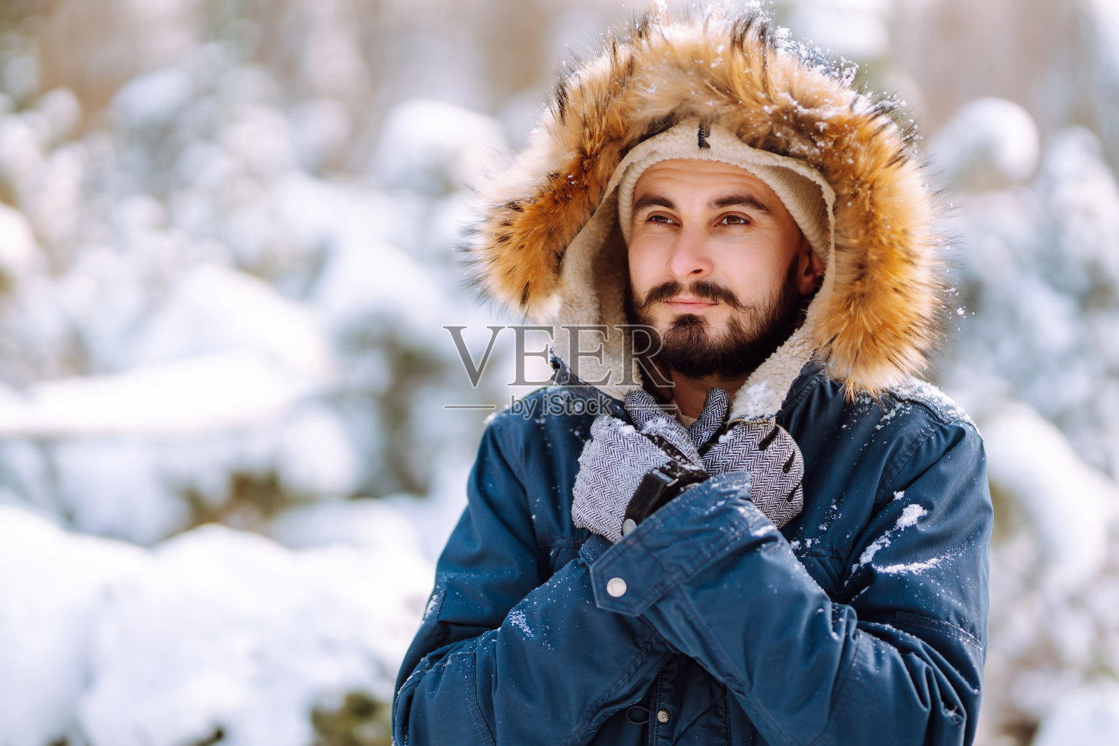 雪天森林里的年轻人的肖像。照片摄影图片