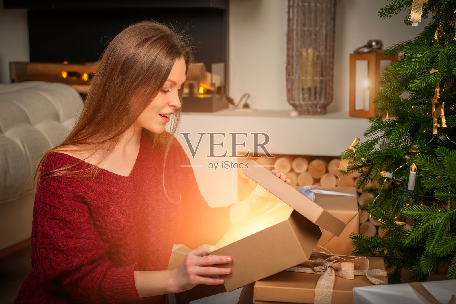 圣诞快乐,节日快乐!一个年轻漂亮的女孩在新年前夜拿着一盒礼物。照片摄影图片
