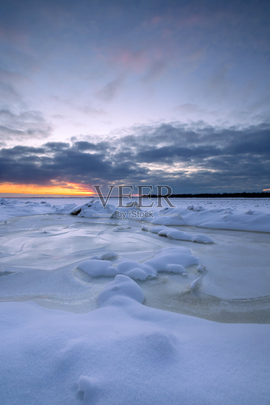 冰封的河面上美丽的冬日落日。照片摄影图片