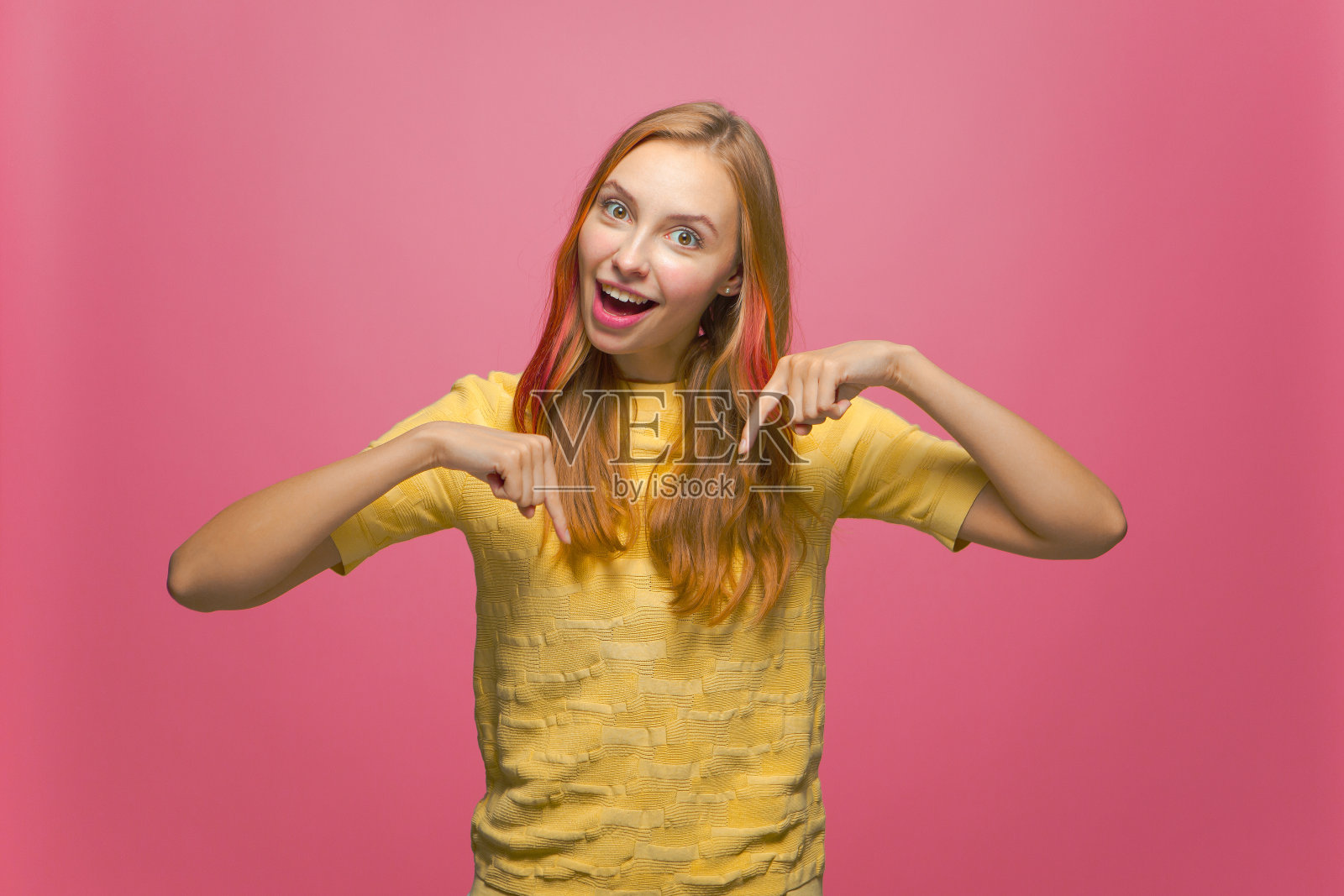 酷的报价。小女孩惊喜地指着下面。兴奋的女性博主显示链接订阅粉红色的背景照片摄影图片