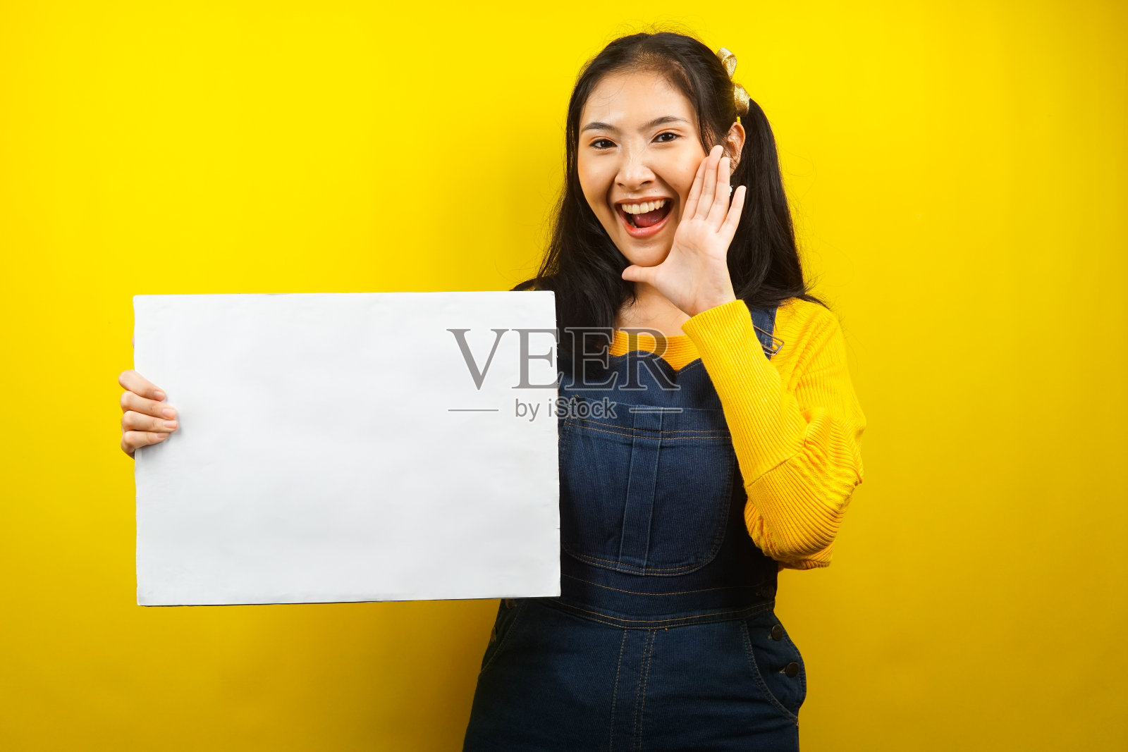 漂亮可爱的年轻女子欢快地拿着空白的空横幅、广告牌、白板、白板招牌、白色广告牌,在文案空间展示东西,促销照片摄影图片