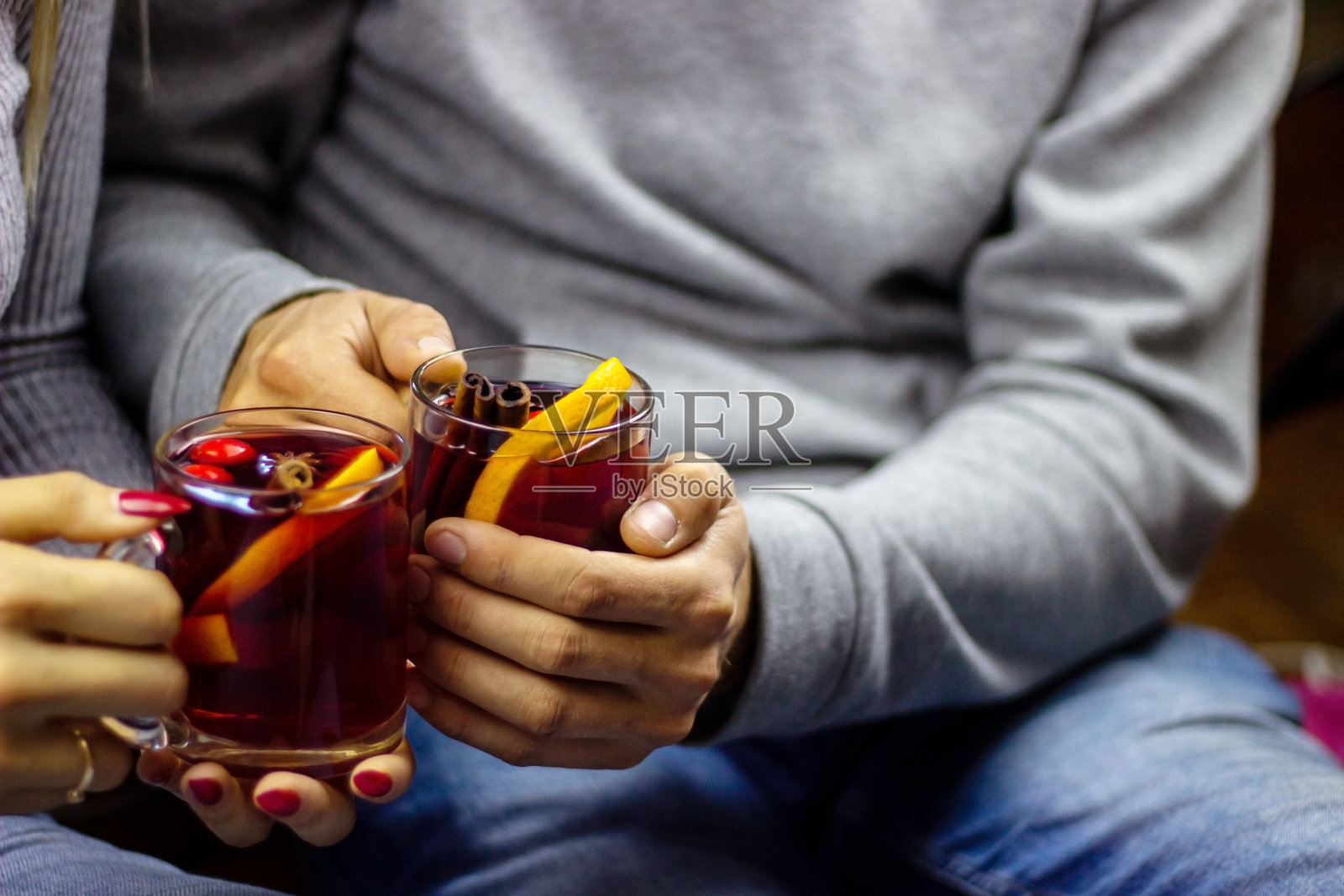 男女手捧热红酒,香辛料。照片摄影图片
