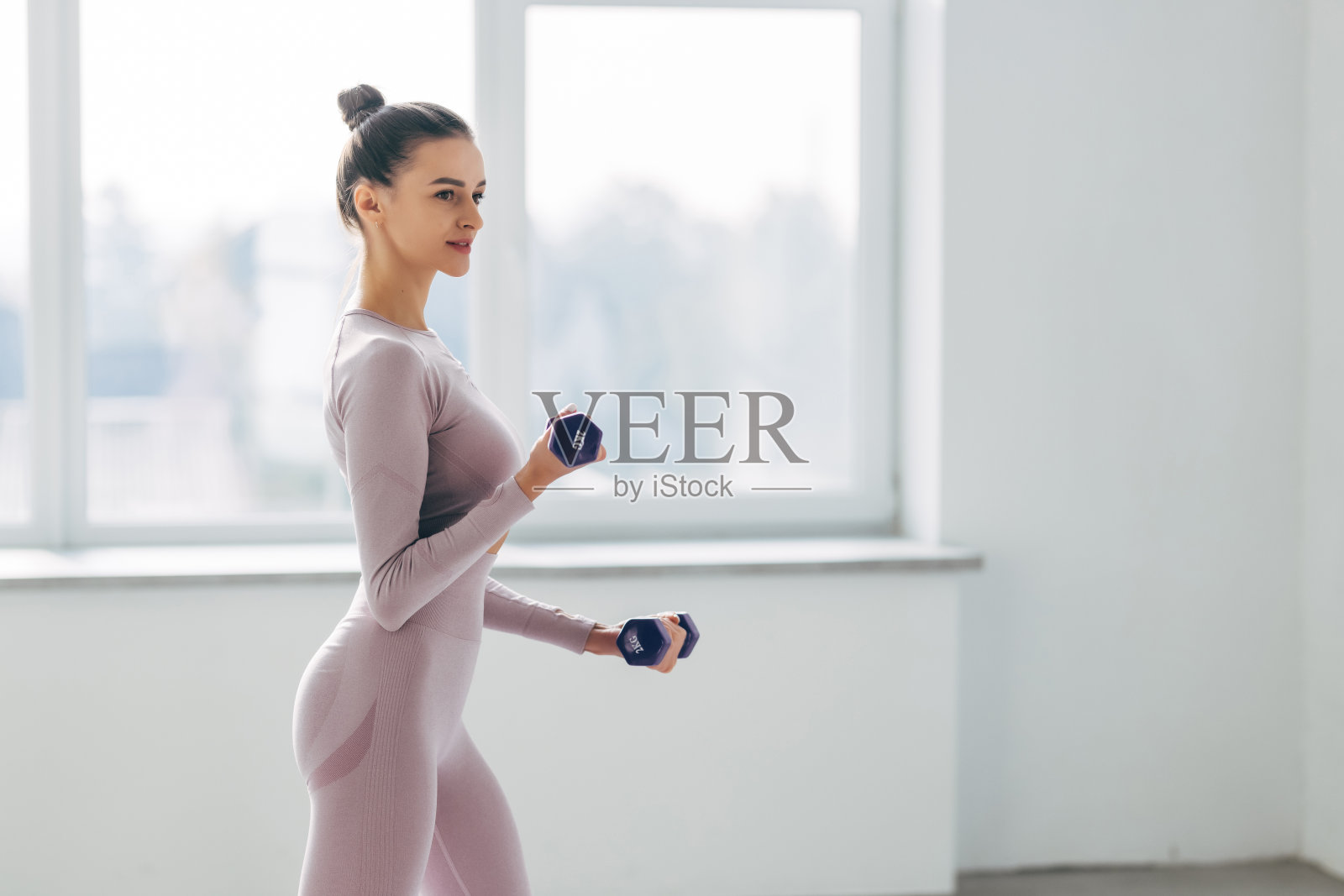 女运动员正在做手臂运动。肌肉健美模特在健身房用哑铃锻炼的照片照片摄影图片