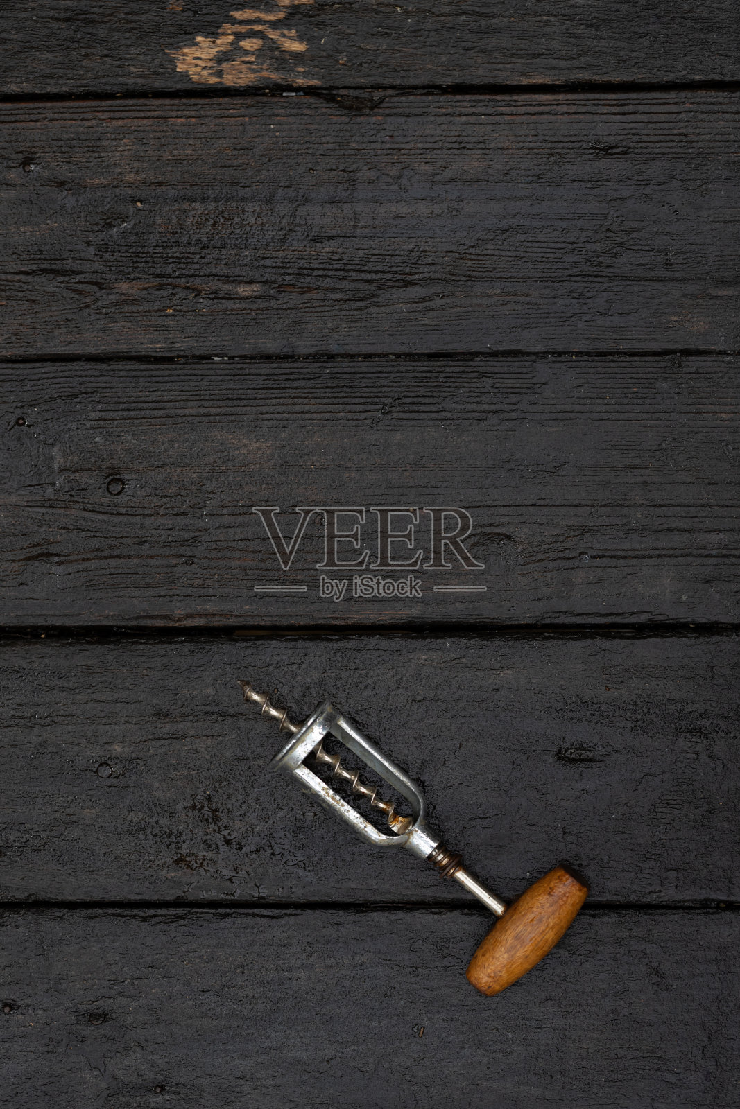开瓶用的开瓶器放在深色的木制背景上。照片摄影图片