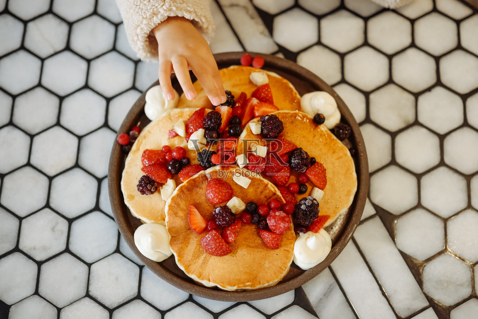 小女孩吃早餐薄饼和水果照片摄影图片