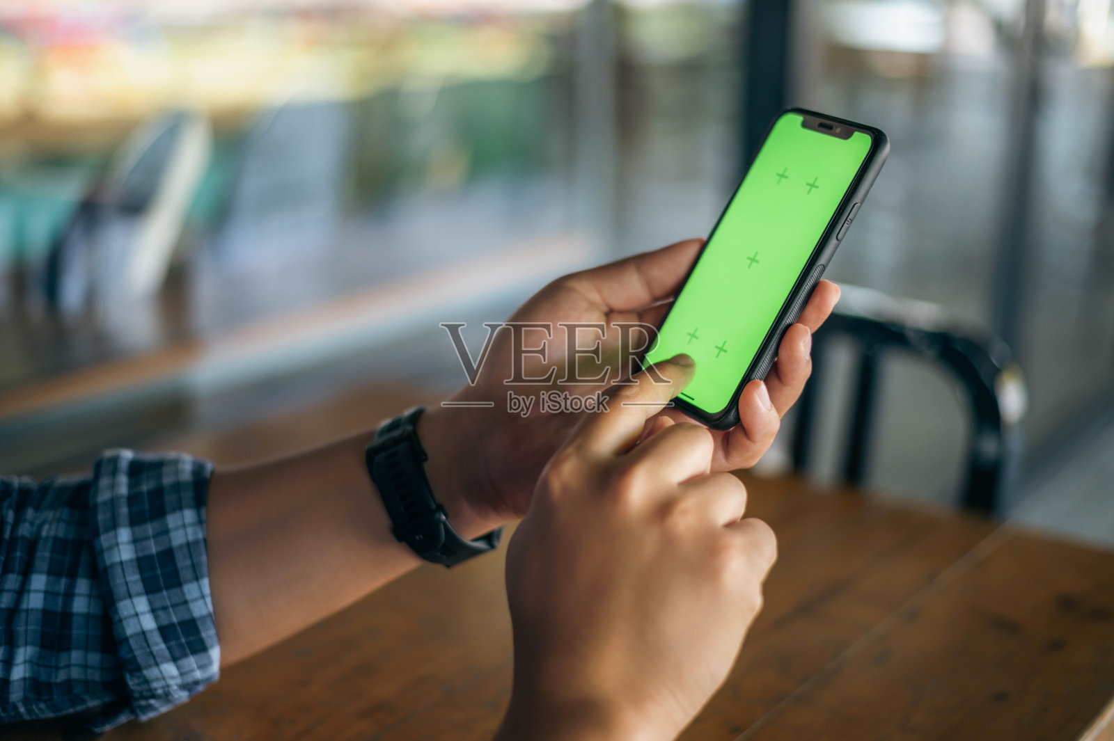男性手握绿屏智能手机的特写照片摄影图片