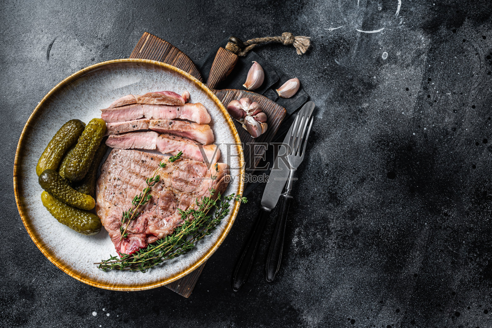 烧烤晚餐-猪颈肉配上烤盘。黑色背景。前视图。本空间照片摄影图片