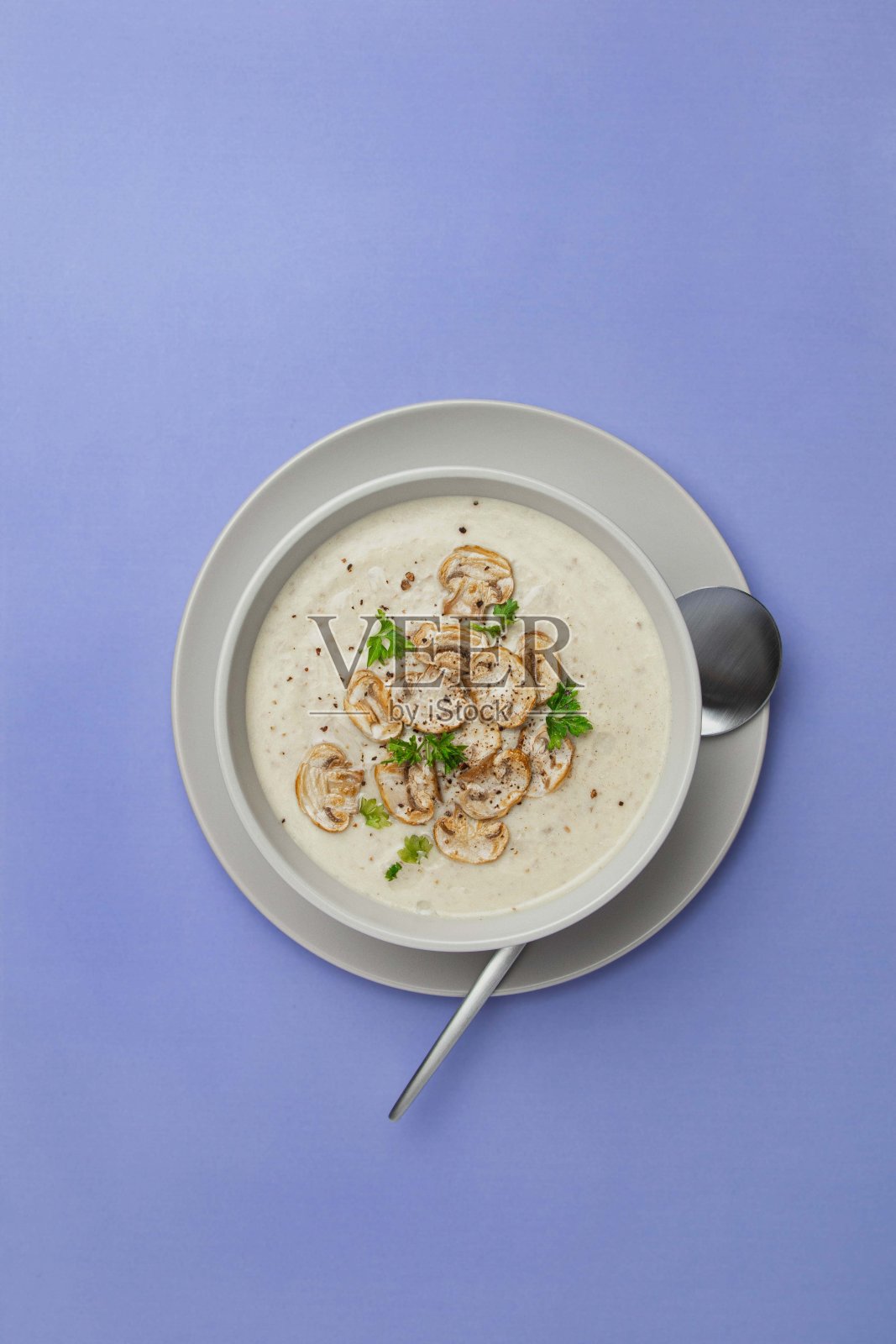 碗以紫罗兰色香槟酒奶油汤,紫色底色。俯视图,复制空间。照片摄影图片