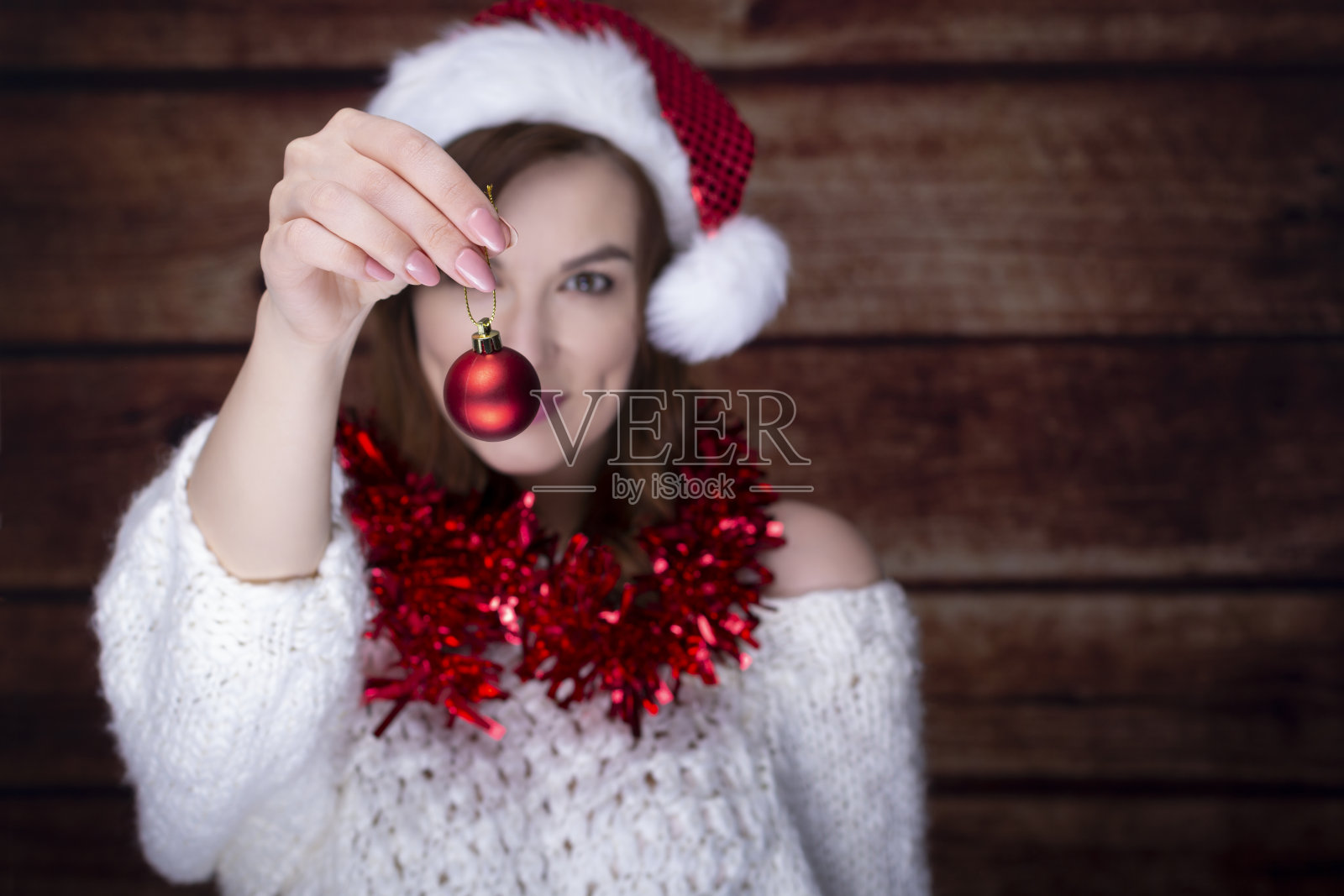穿着暖和毛衣,拿着圣诞红球的妇女照片摄影图片