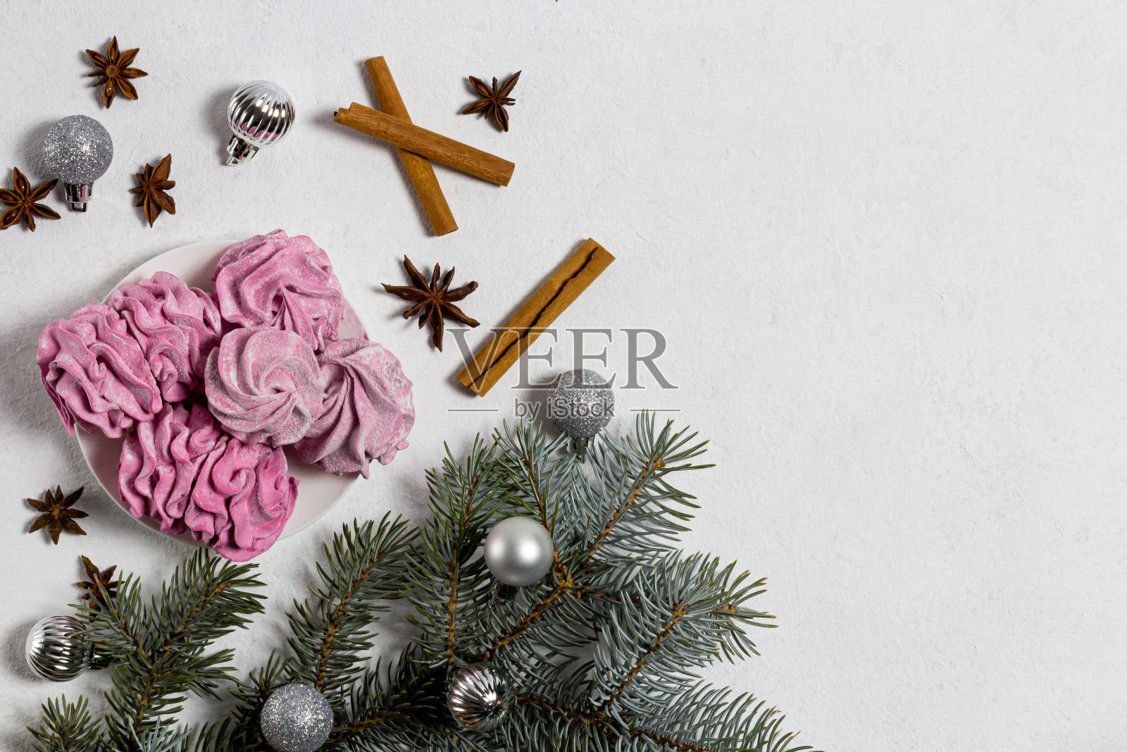 新年的成分。圣诞灰球装饰在白色的背景。棉花糖,云杉枝,八角,肉桂棒。平铺,俯视图,复制空间照片摄影图片