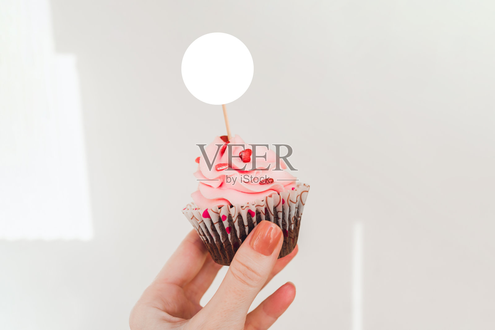 蛋糕顶饰的模型拿在手里。圆形标签纸杯蛋糕模型为您的设计。照片摄影图片