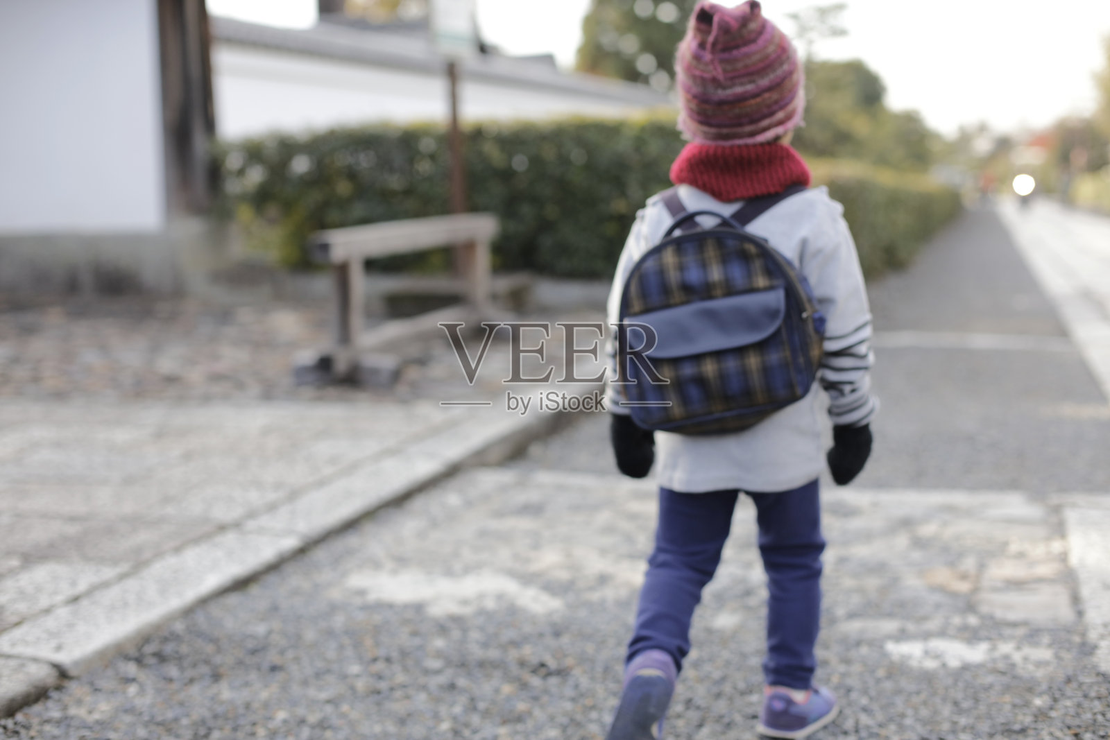 一个冬天走路上学的男孩。日本的寺庙漫步。照片摄影图片