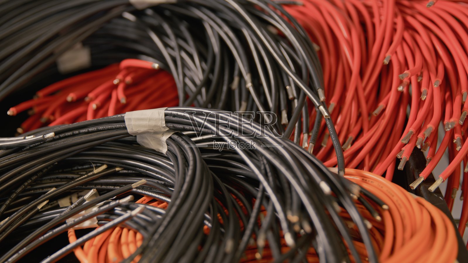 堆卷起的红色和黑色电缆侧面视图照片摄影图片