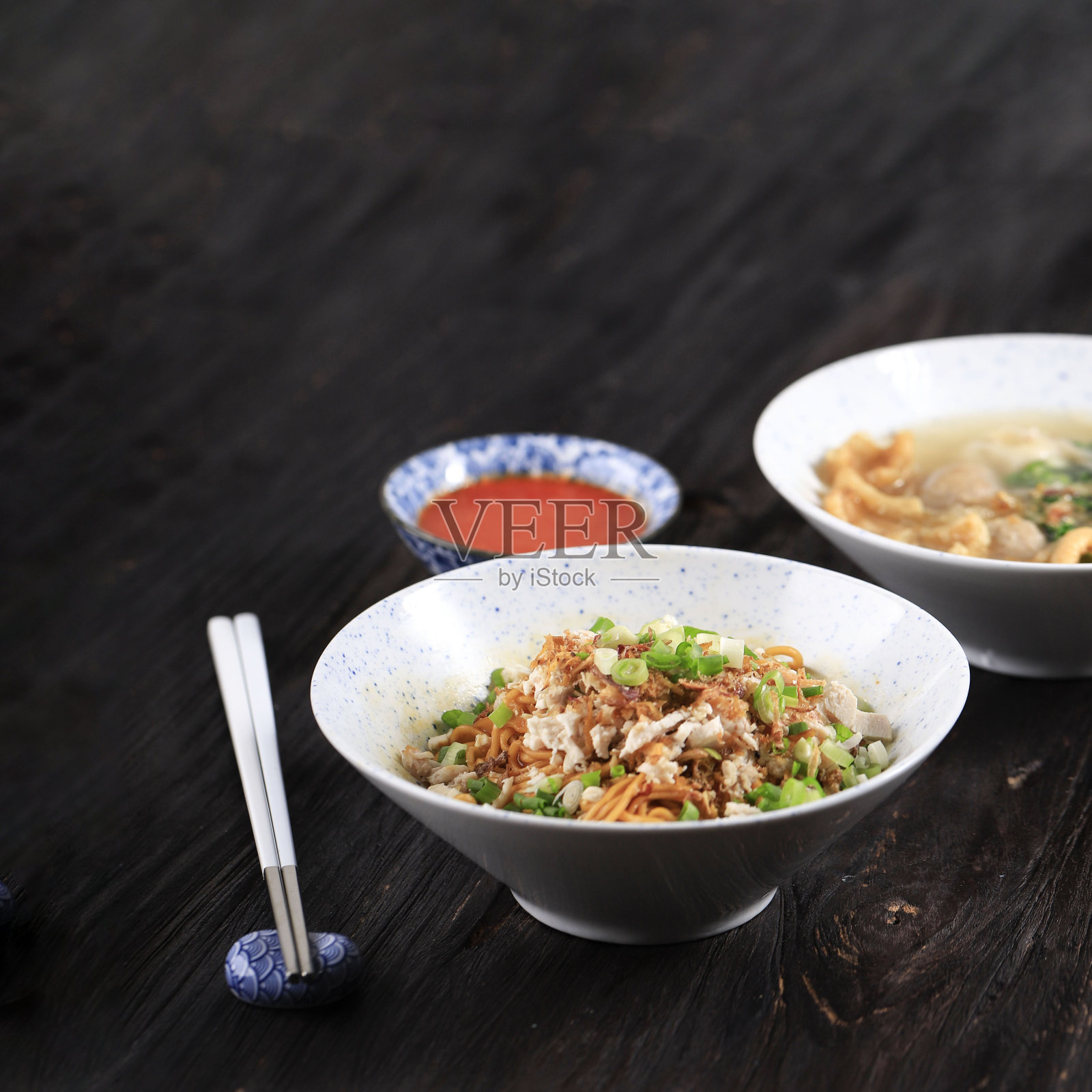 拌鸡肉末和蔬菜的面条。从酱油中品尝甜味。用陶瓷碗盛着参巴酱照片摄影图片