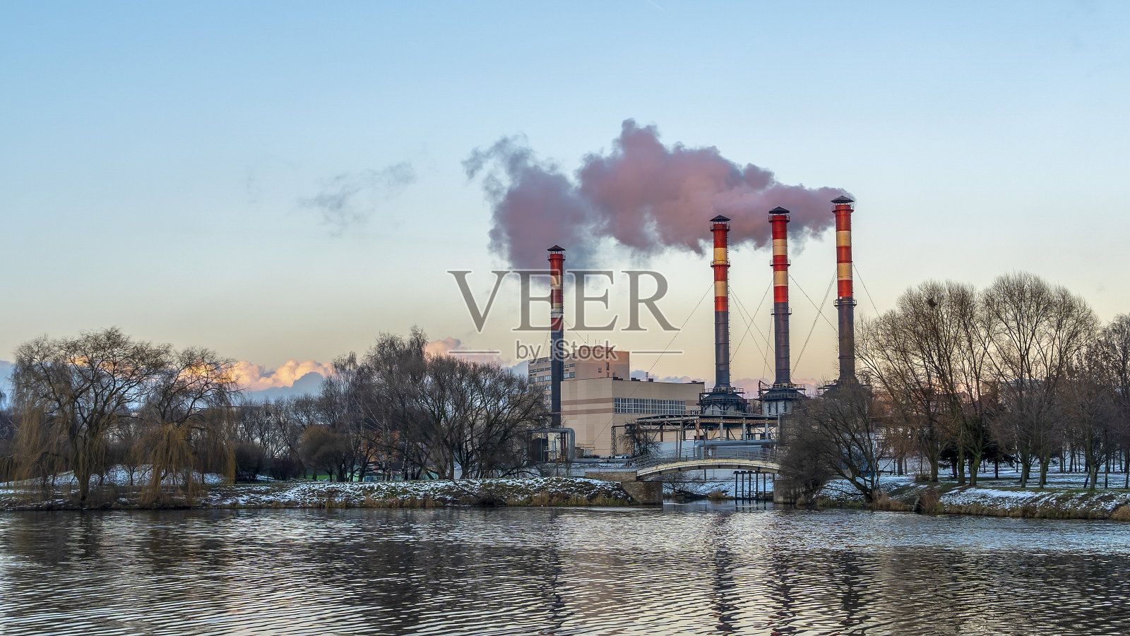城市海滨附近火电厂冒烟的烟囱。冬天。工业和自然背景。照片摄影图片