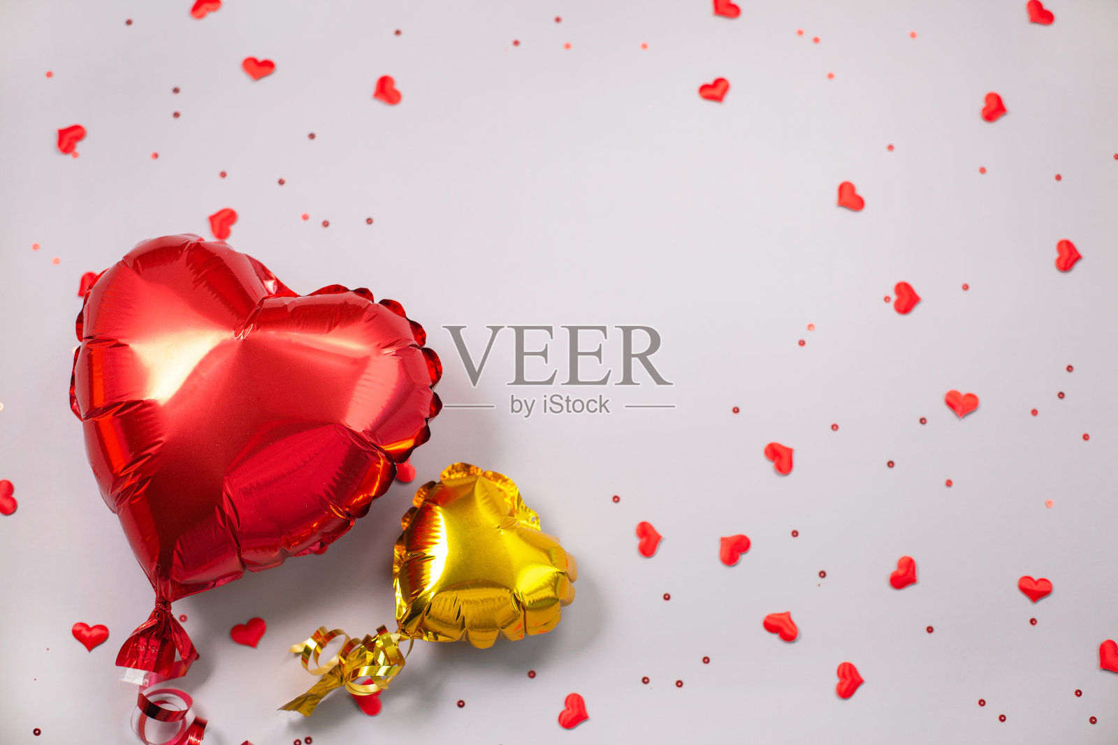 两个心形的气球在节日的灰色背景上衬托。照片摄影图片