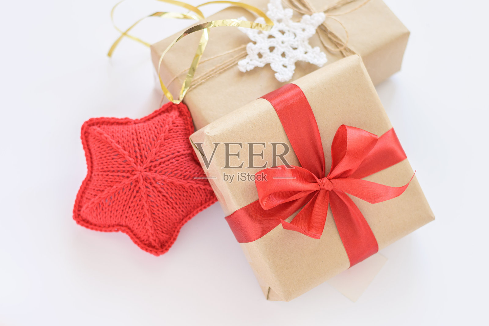 圣诞节和新年装饰礼物。用牛皮纸包着红丝带的礼盒。红色的针织的心。黄麻绳和钩针雪花盒照片摄影图片
