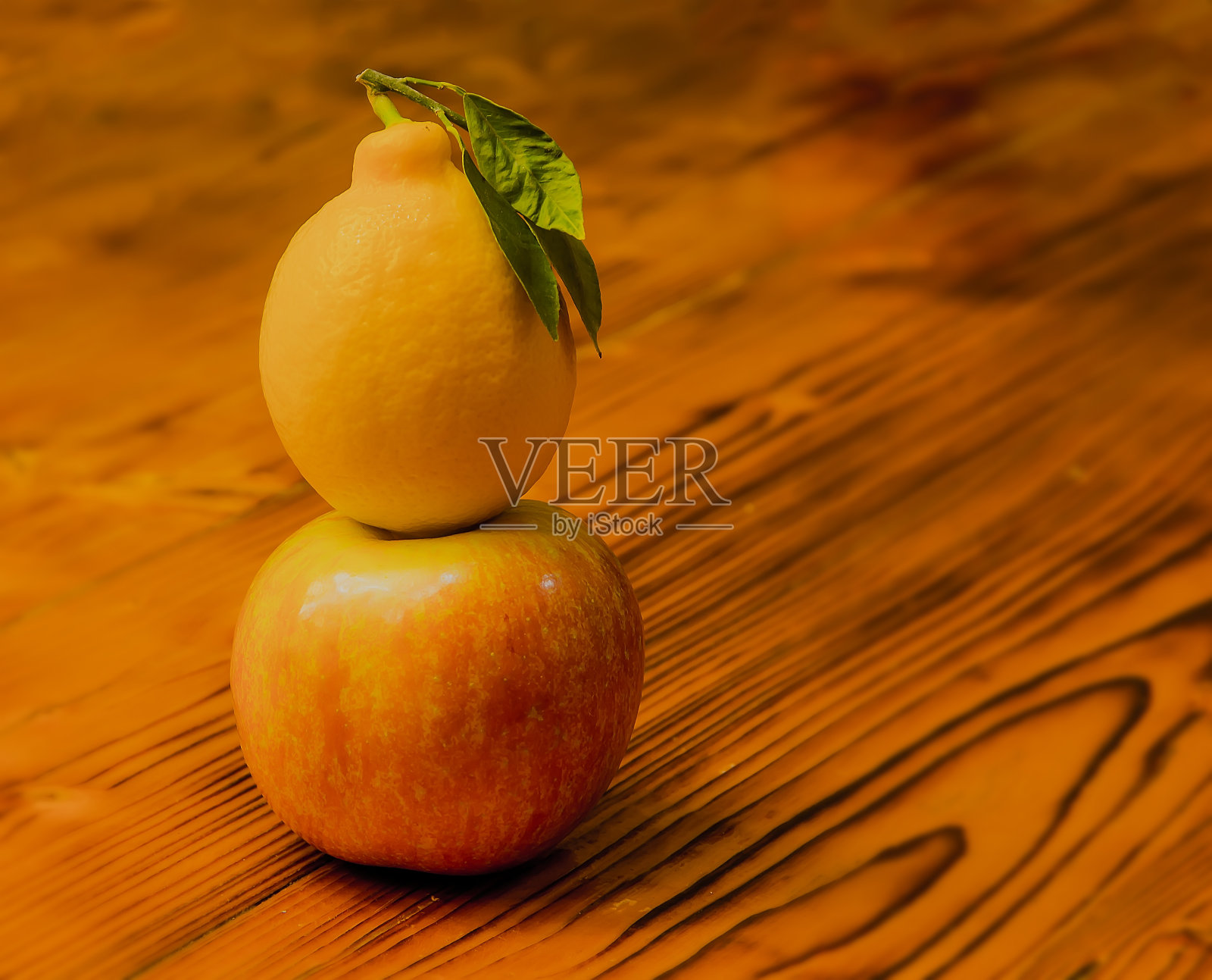 黄色多汁的柠檬放在成熟漂亮的苹果上。照片摄影图片