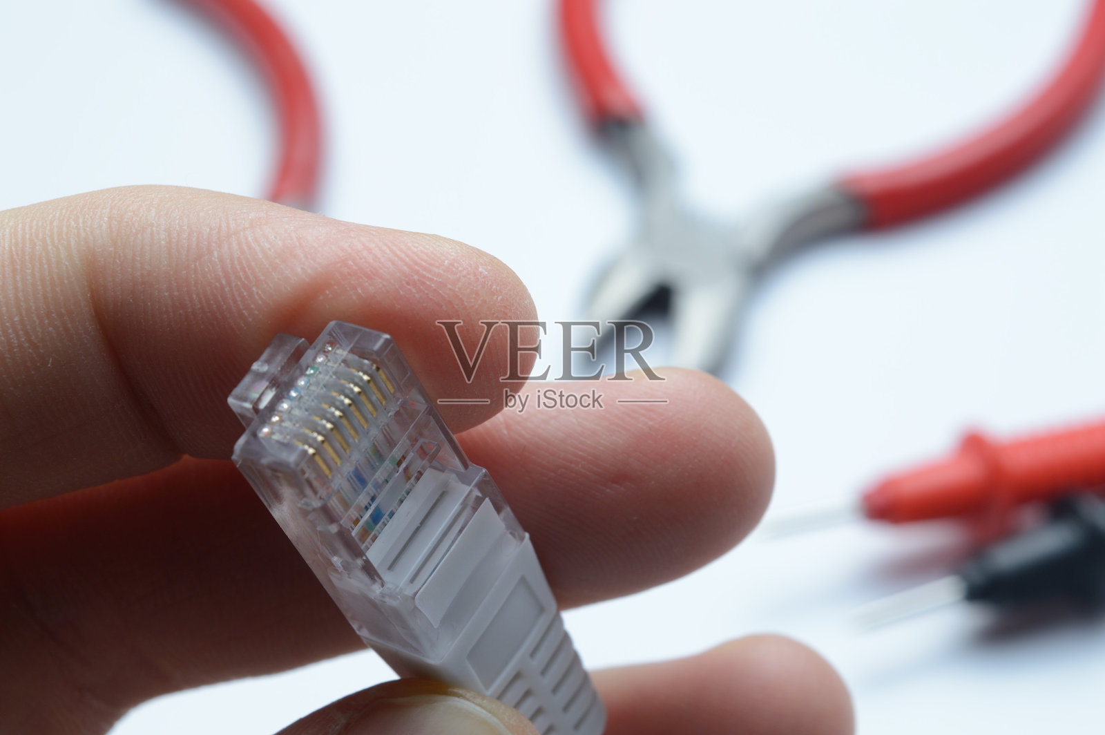 互联网电缆与连接器rj 45在手中的主人。以工具为背景。照片摄影图片