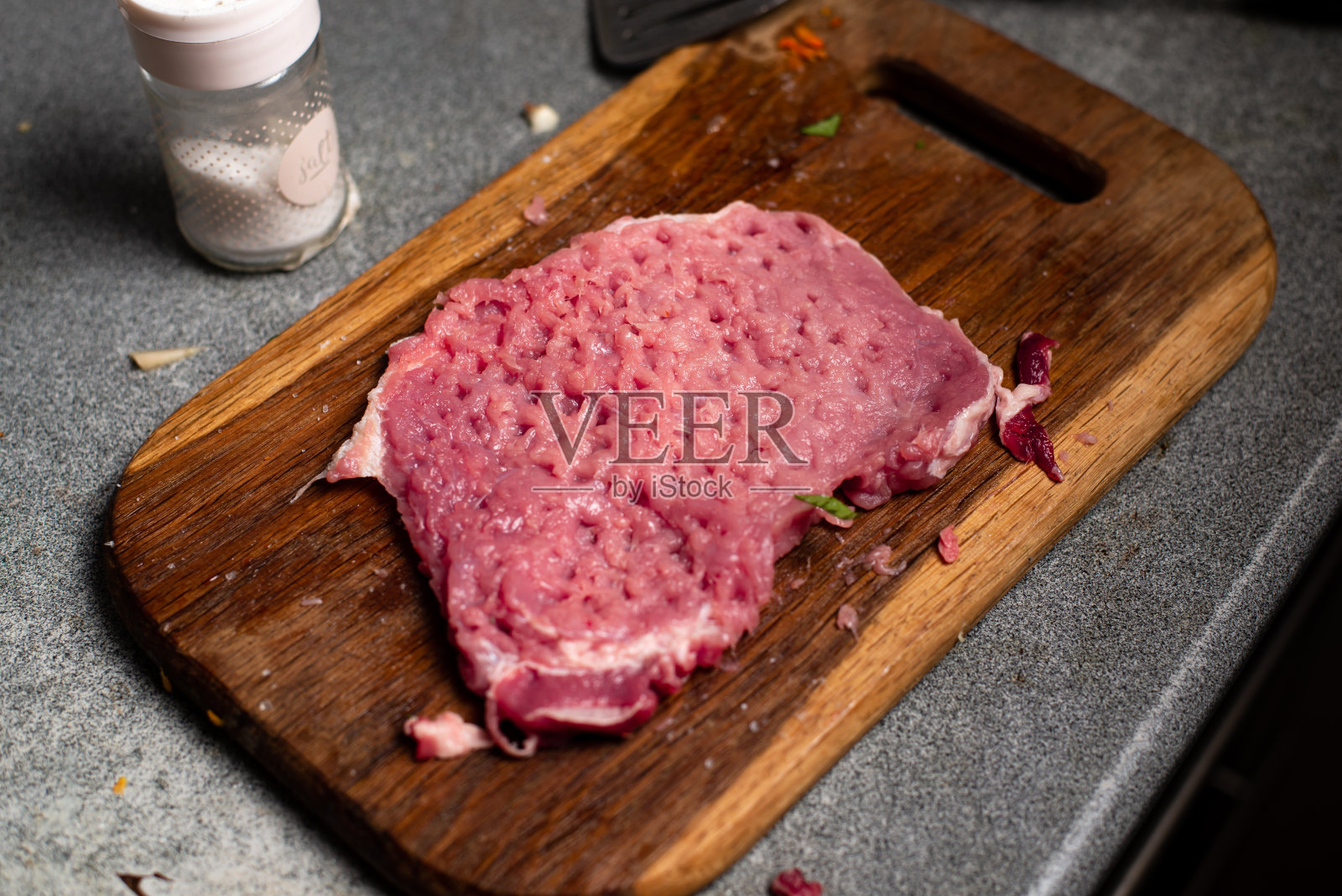 砧板上锤碎的一块生猪肉。照片摄影图片